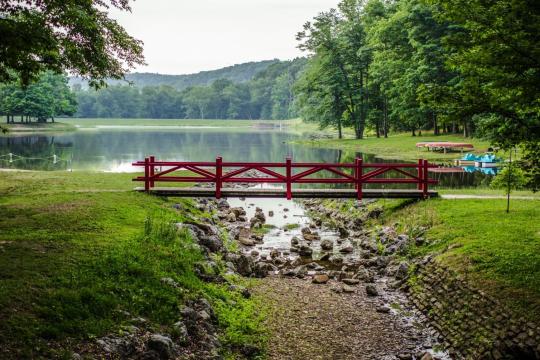 Red pedestrian bridge crossing over creek mouth